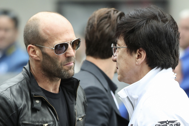 Actors Jason Statham, left and Jackie Chan talk, prior the 84th 24-hour Le Mans endurance race, in Le Mans, western France, Saturday, June 18, 2016. (AP Photo/Kamil Zihnioglu)